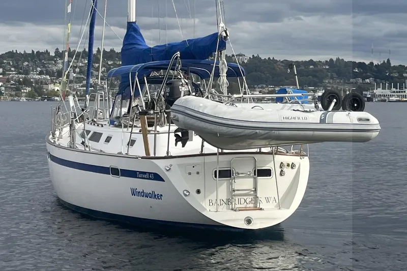  Yacht Photos Pics 1989 Taswell 43 sailboat named "Windwalker" with dinghy, moored on calm water.