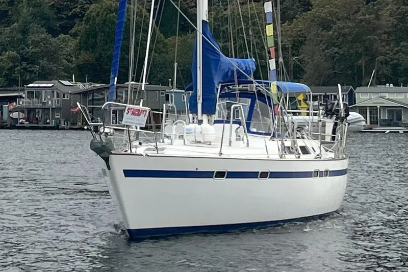  Yacht Photos Pics 1989 Taswell 43 sailboat on a calm lake with forested shoreline.