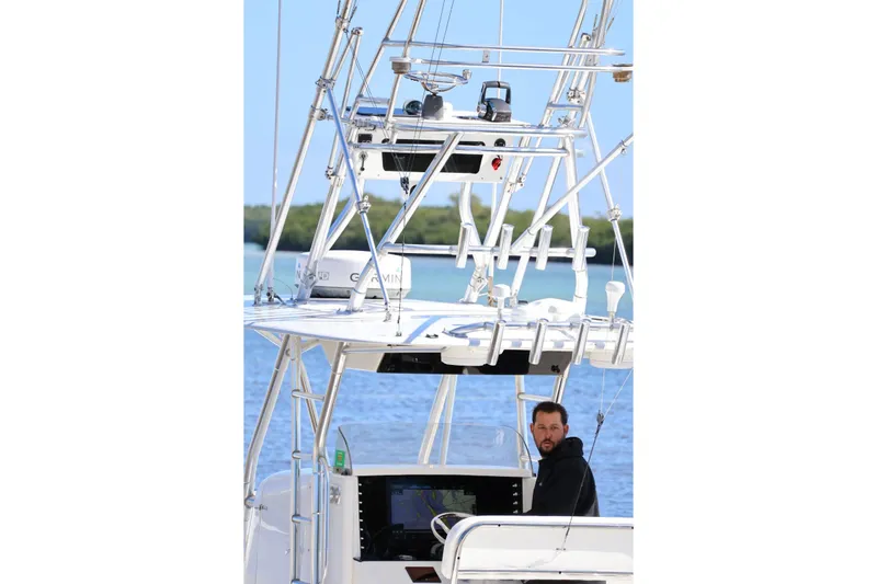  Yacht Photos Pics 2005 Venture 39 Open boat with a person at the helm, navigating on water.