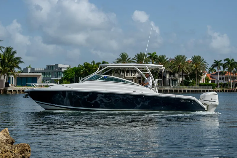 Naider's Yacht Photos Pics 2016 Jupiter 34 LX boat cruising on a calm waterway with palm trees in the background.