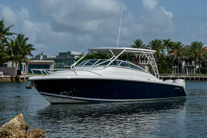 Naider's Yacht Photos Pics 2016 Jupiter 34 LX boat on calm water with palm trees in the background.
