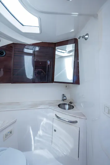 Naider's Yacht Photos Pics 2016 Jupiter 34 LX boat bathroom with sink, mirror, and wooden cabinets.