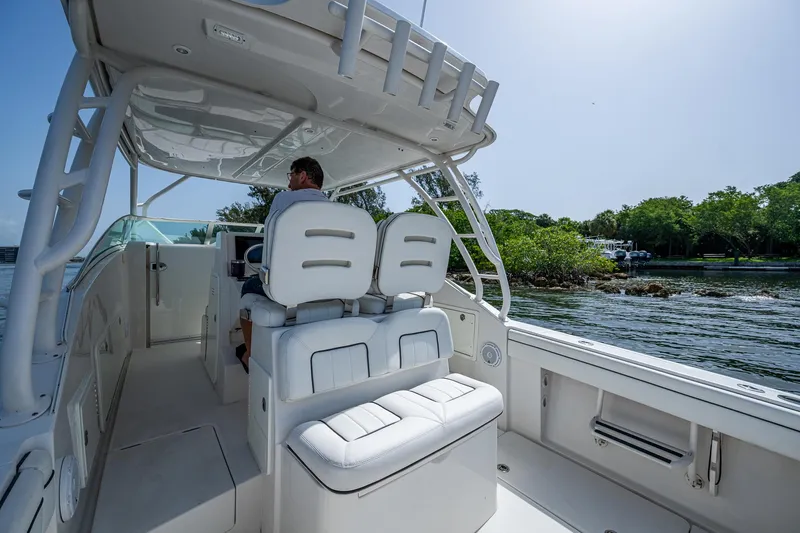 Naider's Yacht Photos Pics 2016 Jupiter 34 LX boat interior with white seating, cruising near lush shoreline.