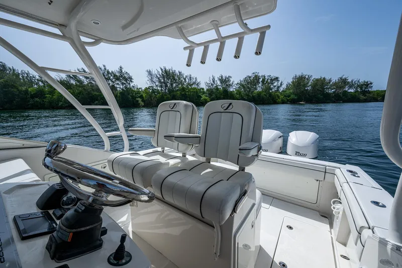 Naider's Yacht Photos Pics 2016 Jupiter 34 LX boat interior with dual seats and steering, overlooking calm waters.