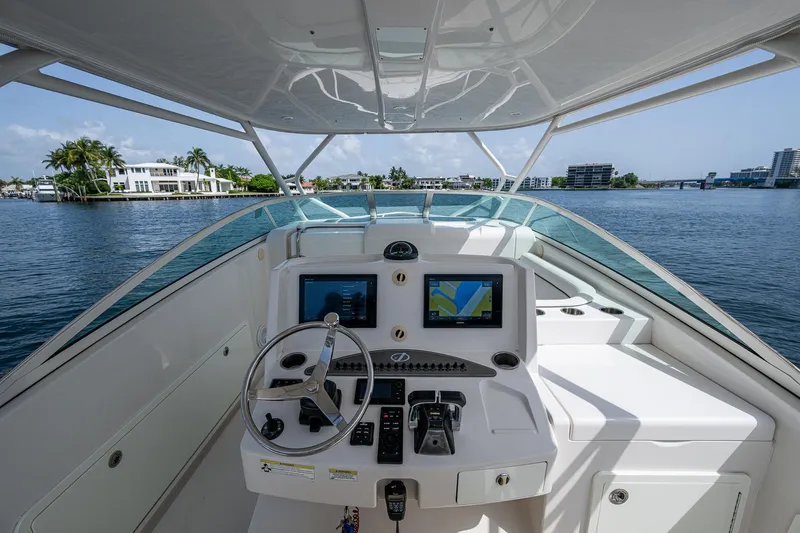 Naider's Yacht Photos Pics 2016 Jupiter 34 LX boat helm with navigation screens, steering wheel, and waterfront view.