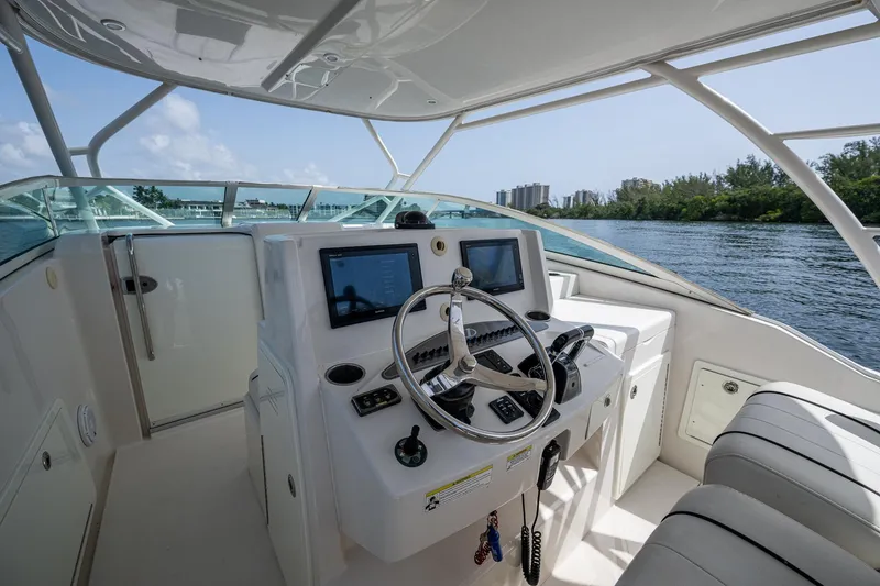 Naider's Yacht Photos Pics 2016 Jupiter 34 LX boat helm with dual screens and steering wheel on a sunny day.
