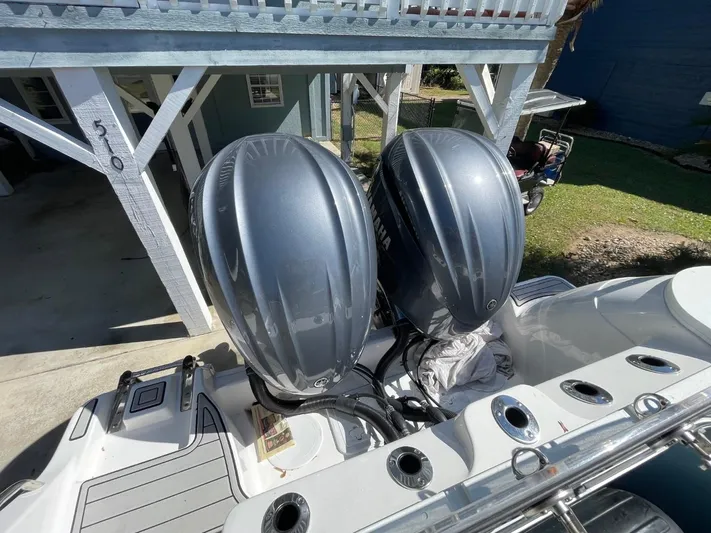  Yacht Photos Pics 2024 Sea Fox 288 Commander with dual outboard engines, parked under a wooden structure.