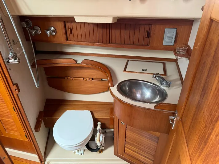 Essence Yacht Photos Pics 1998 Island Packet 40 yacht bathroom with wooden cabinetry and stainless steel sink.