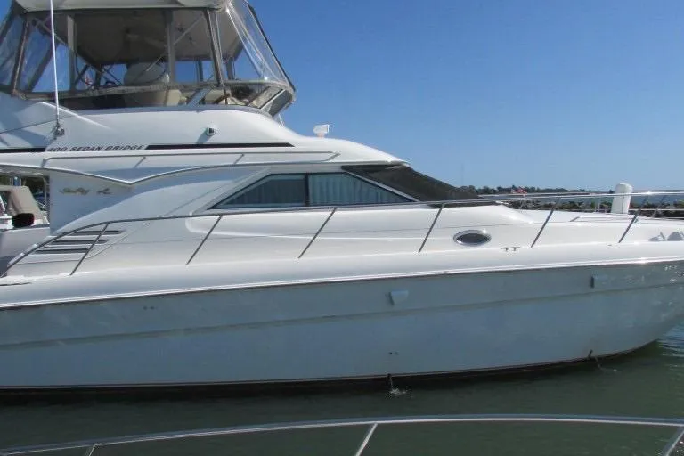  Yacht Photos Pics 2000 Sea Ray 400 Sedan Bridge yacht on calm water under clear blue sky.