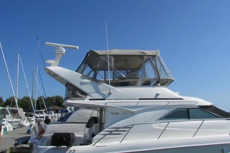  Yacht Photos Pics 2000 Sea Ray 400 Sedan Bridge yacht docked under clear blue sky.