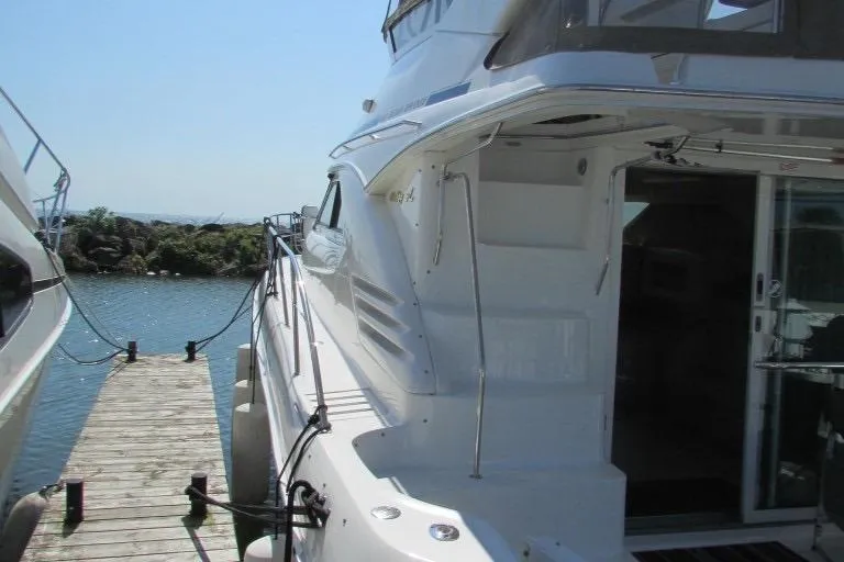  Yacht Photos Pics 2000 Sea Ray 400 Sedan Bridge yacht docked at a marina, side view.