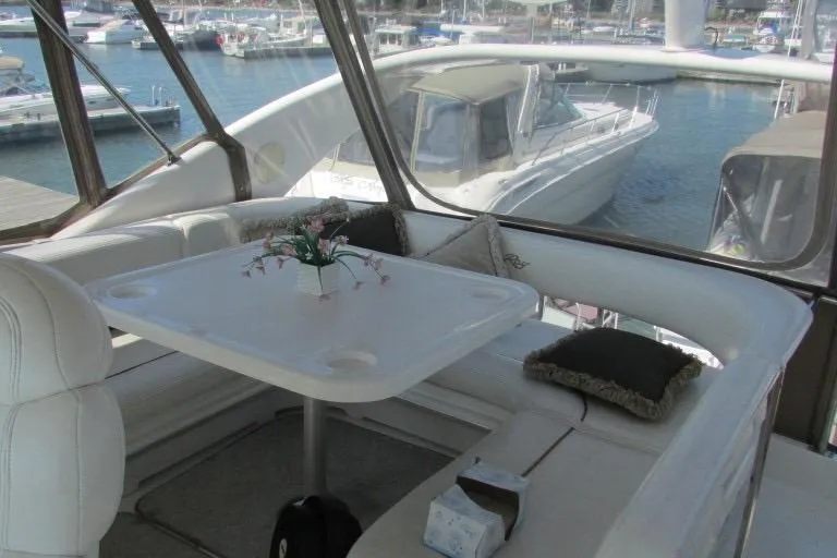  Yacht Photos Pics Interior of 2000 Sea Ray 400 Sedan Bridge with table and seating, overlooking marina.
