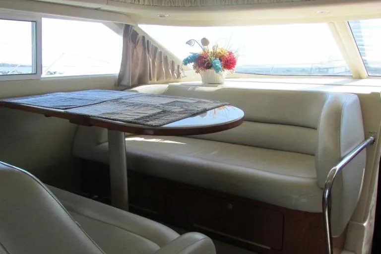  Yacht Photos Pics Interior of 2000 Sea Ray 400 Sedan Bridge with dining area and floral centerpiece.