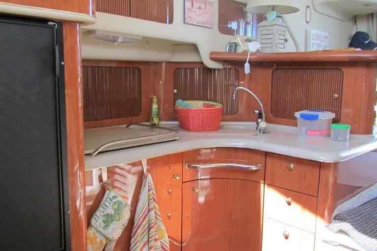  Yacht Photos Pics Interior of 2000 Sea Ray 400 Sedan Bridge yacht kitchen with wood cabinetry and sink.