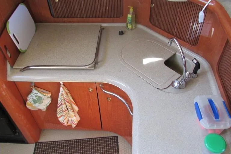  Yacht Photos Pics Compact kitchen area in a 2000 Sea Ray 400 Sedan Bridge yacht, featuring a sink and storage.