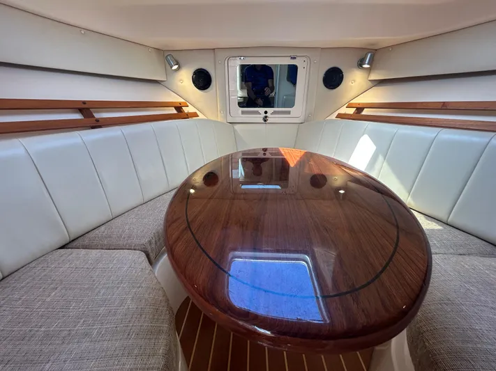 She Bot It II Yacht Photos Pics Interior of 2007 Grady-White Express 305 boat with elegant wood table and cushioned seating.