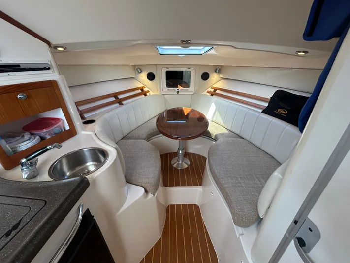 She Bot It II Yacht Photos Pics 2007 Grady-White Express 305 cabin interior with seating, table, and kitchenette.