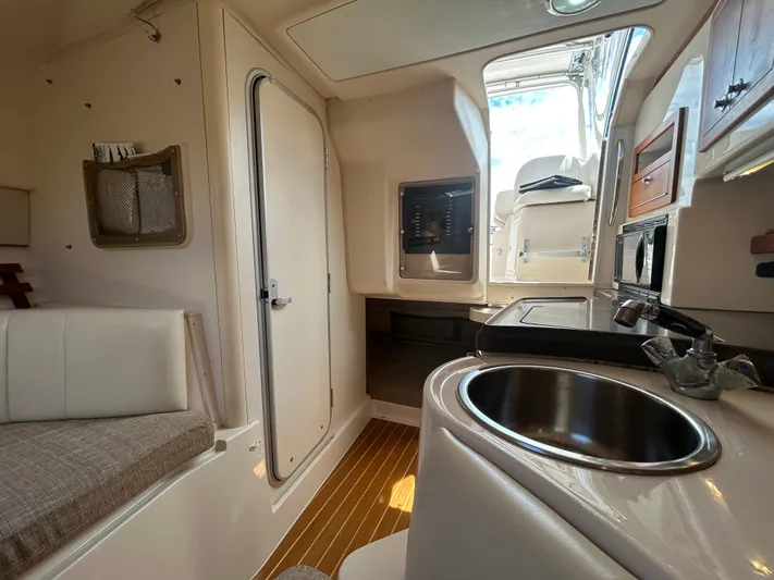 She Bot It II Yacht Photos Pics 2007 Grady-White Express 305 interior with kitchenette, sink, and seating area.