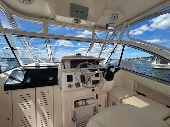She Bot It II Yacht Photos Pics 2007 Grady-White Express 305 boat cockpit with steering wheel, overlooking scenic water view.