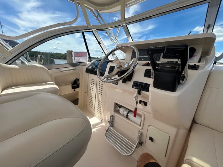 She Bot It II Yacht Photos Pics 2007 Grady-White Express 305 boat helm with steering wheel and controls, under clear blue sky.