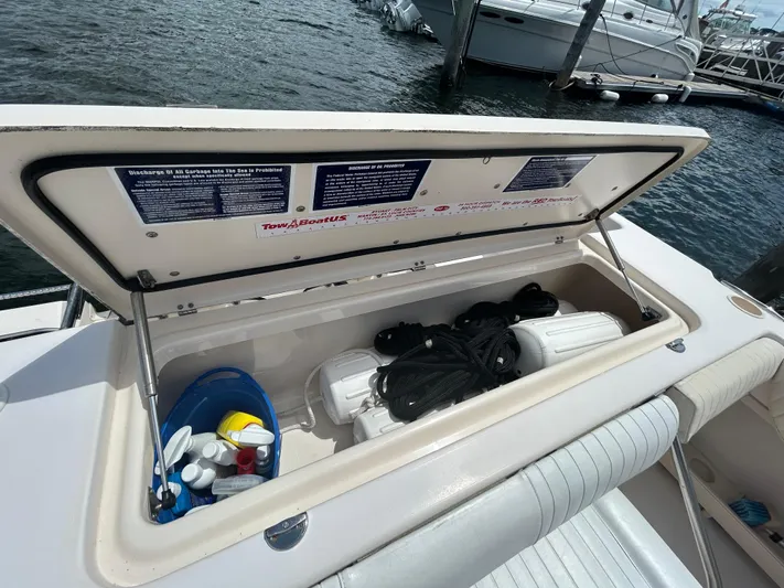 She Bot It II Yacht Photos Pics Open storage compartment on 2007 Grady-White Express 305 boat, containing ropes and cleaning supplies.