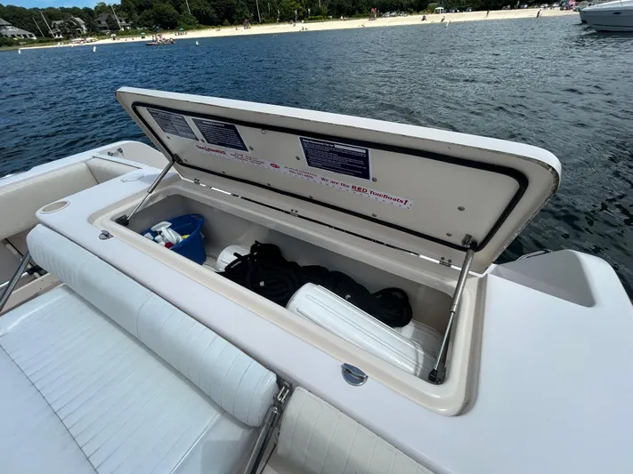 She Bot It II Yacht Photos Pics Open storage compartment on 2007 Grady-White Express 305 boat, near a sandy beach.