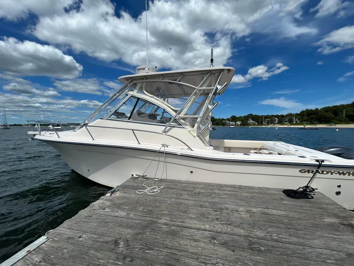 She Bot It II Yacht Photos Pics 2007 Grady-White Express 305 boat docked by the water under a partly cloudy sky.