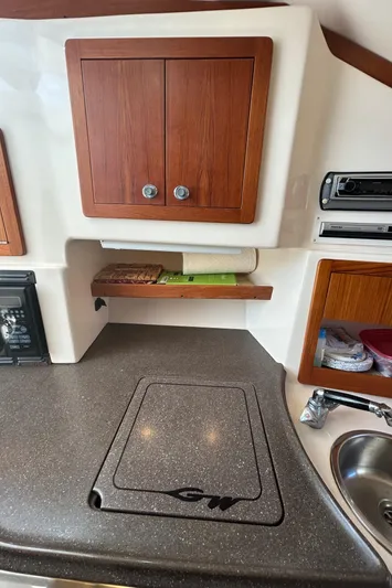 She Bot It II Yacht Photos Pics 2007 Grady-White Express 305 boat interior with kitchenette, wooden cabinets, and countertop.