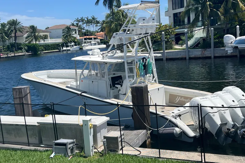  Yacht Photos Pics 2011 Yellowfin 42 Offshore boat docked by waterfront homes, surrounded by palm trees.