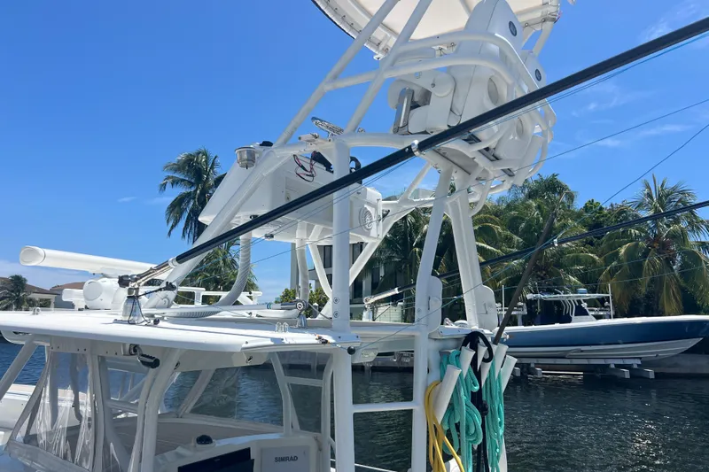  Yacht Photos Pics 2011 Yellowfin 42 Offshore boat with fishing gear, docked near palm trees under clear blue sky.