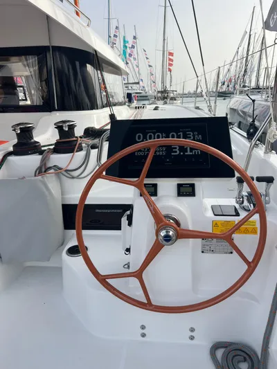  Yacht Photos Pics 2024 Excess 14 yacht helm with wooden steering wheel and digital display.