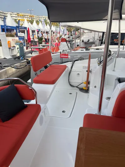  Yacht Photos Pics 2024 Excess 14 yacht interior with red seating at a boat show.