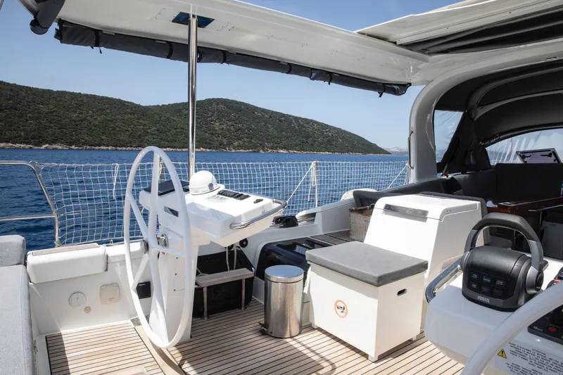  Yacht Photos Pics Luxurious 2020 Jeanneau 64 yacht cockpit with scenic ocean view and modern steering wheel.