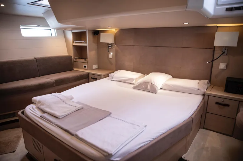  Yacht Photos Pics Luxurious interior cabin of 2020 Jeanneau 64 yacht with elegant bedding and seating.