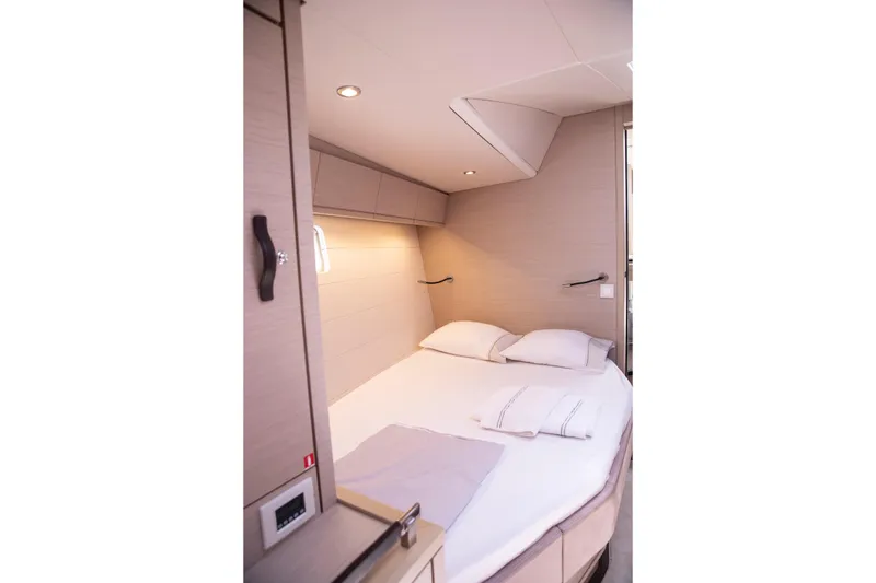  Yacht Photos Pics Luxurious cabin interior of 2020 Jeanneau 64 yacht with cozy bed and modern lighting.