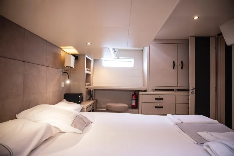  Yacht Photos Pics Luxurious cabin interior of 2020 Jeanneau 64 yacht with modern furnishings and cozy bedding.