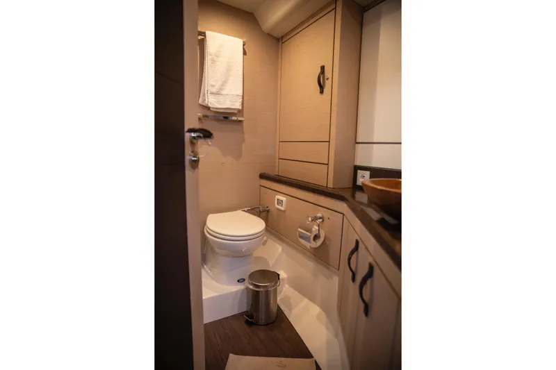  Yacht Photos Pics Bathroom interior of 2020 Jeanneau 64 yacht, featuring modern fixtures and wooden cabinetry.