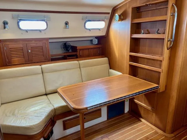 Pelican Yacht Photos Pics Interior of 2008 Island Packet 370 sailboat with wooden table and beige seating.