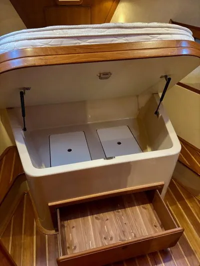 Pelican Yacht Photos Pics Interior storage compartment in a 2008 Island Packet 370 sailboat with wooden flooring.