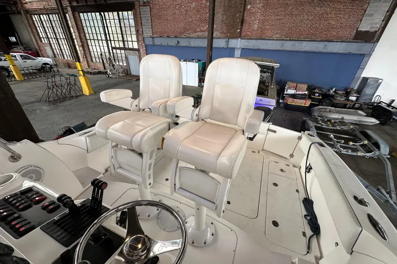  Yacht Photos Pics 2006 Sunseeker Sportfisher 37 boat interior with dual captain chairs in a warehouse setting.