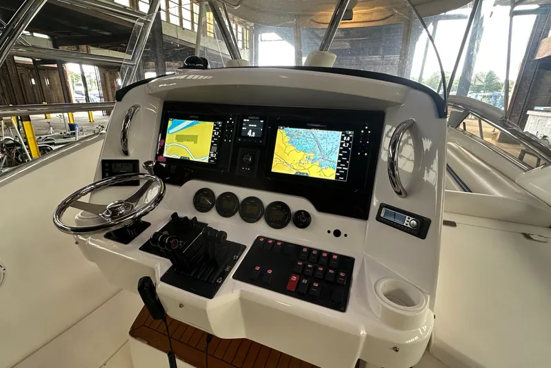  Yacht Photos Pics Control panel of 2006 Sunseeker Sportfisher 37 with navigation screens and steering wheel.