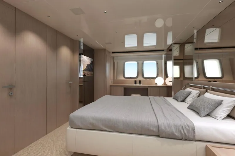  Yacht Photos Pics Luxurious bedroom interior of 2026 Sanlorenzo SX76 yacht with modern design and large windows.