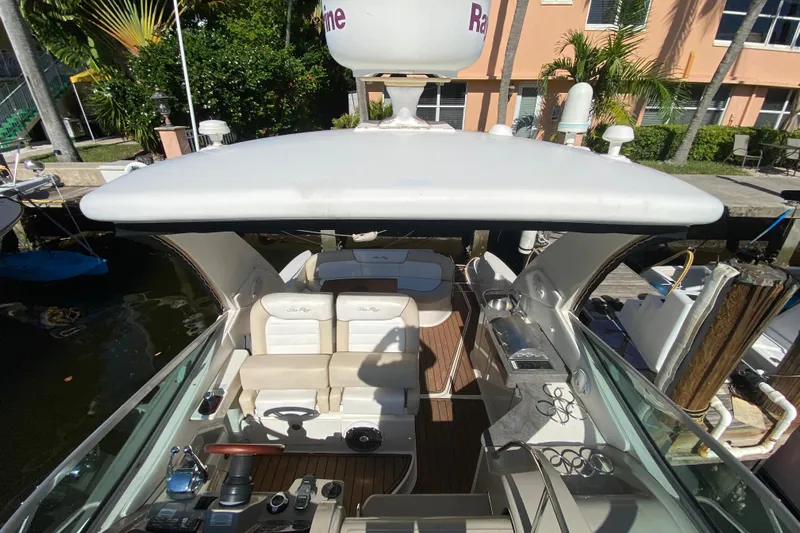  Yacht Photos Pics 2012 Sea Ray 330 Sundancer yacht interior with seating and helm, docked near palm trees.