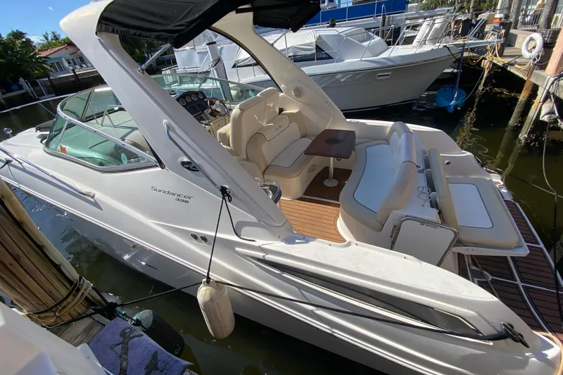  Yacht Photos Pics 2012 Sea Ray 330 Sundancer boat docked, featuring spacious seating and sleek design.