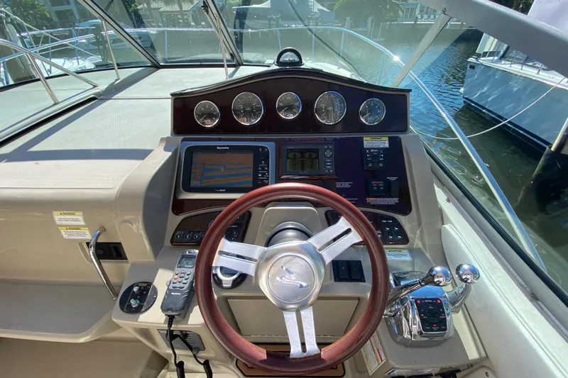  Yacht Photos Pics Cockpit of 2012 Sea Ray 330 Sundancer with steering wheel and navigation controls.