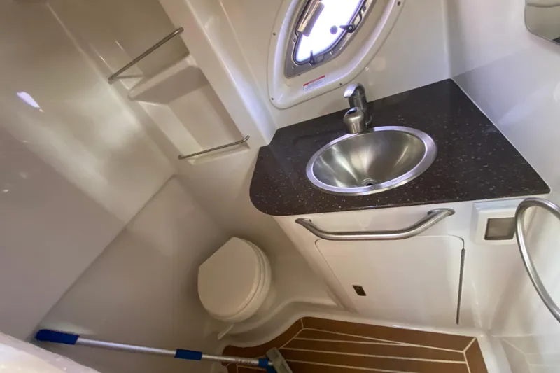  Yacht Photos Pics 2012 Sea Ray 330 Sundancer bathroom with sink, toilet, and porthole window.