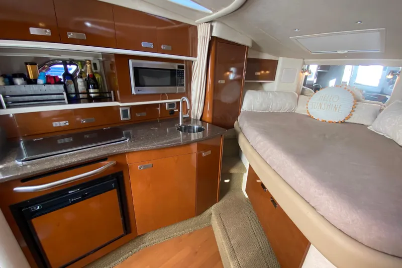  Yacht Photos Pics Interior of 2012 Sea Ray 330 Sundancer with kitchenette and cozy sleeping area.
