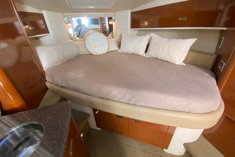  Yacht Photos Pics Cozy cabin interior of 2012 Sea Ray 330 Sundancer with plush bedding and "Hello Sunshine" pillow.