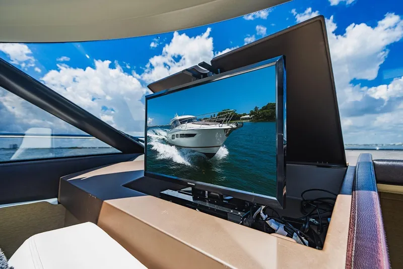  Yacht Photos Pics Luxury yacht interior with TV displaying Prestige 500S, 2018 model, under a bright blue sky.