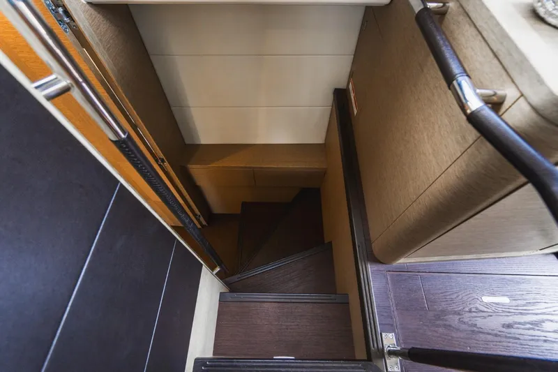  Yacht Photos Pics Staircase inside 2018 Prestige 500S yacht, featuring sleek wooden design and modern handrails.